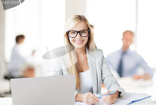 Image of businesswoman with documents in office