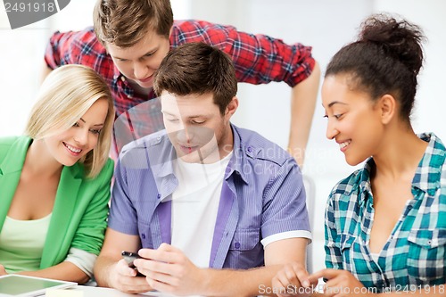 Image of students looking at smartphone at school