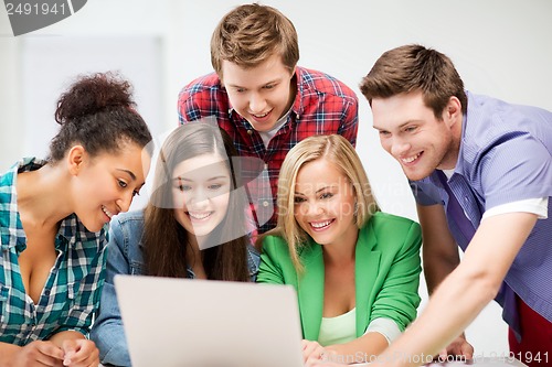 Image of international students looking at laptop at school
