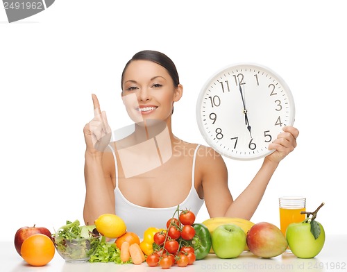 Image of woman with fruits, vegetables and clock
