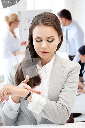 Image of businesswoman looking at alarm clock