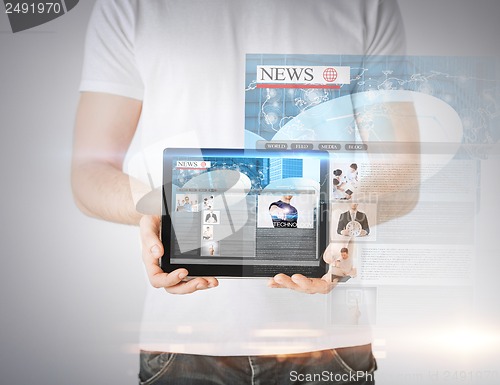 Image of man showing tablet pc with news