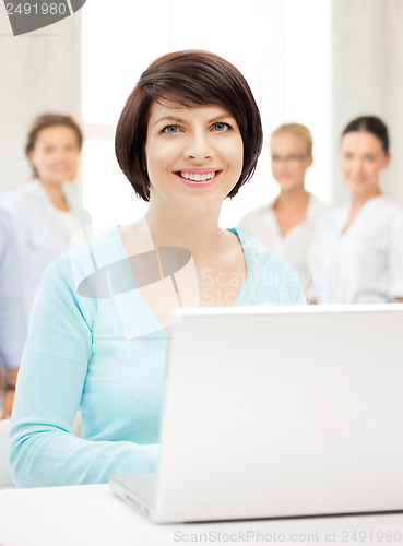 Image of businesswoman with laptop computer at work