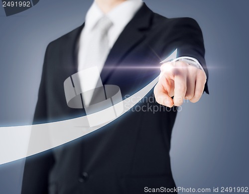 Image of businessman hand showing arrow on virtual screen