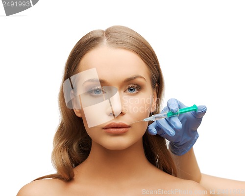 Image of woman face and beautician hands with syringe