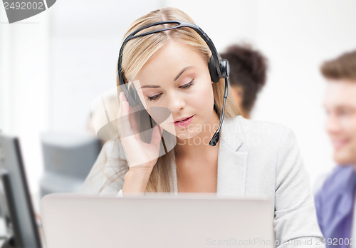 Image of helpline operator with headphones in call centre