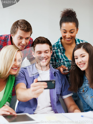 Image of students looking into smartphone at school