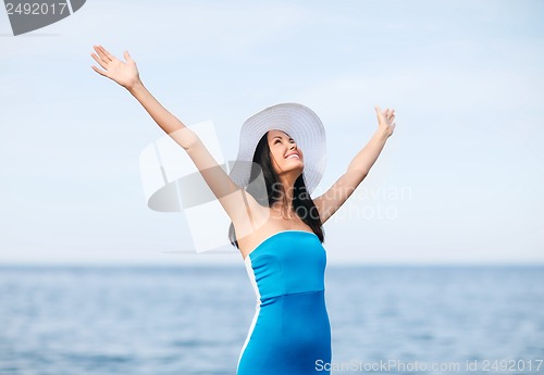 Image of girl with hands up on the beach