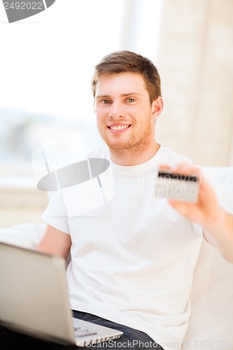 Image of man with laptop and credit card at home