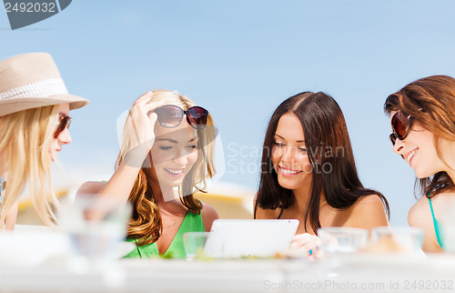 Image of girls looking at tablet pc in cafe