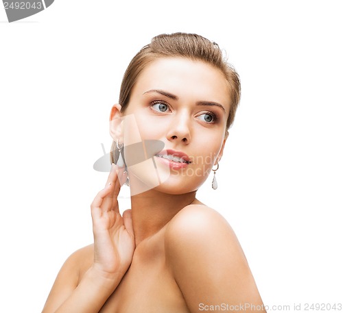Image of woman wearing shiny diamond earrings