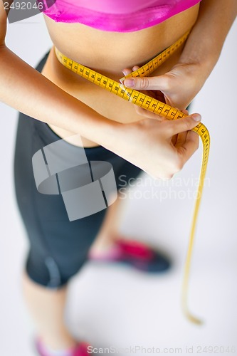 Image of trained belly with measuring tape