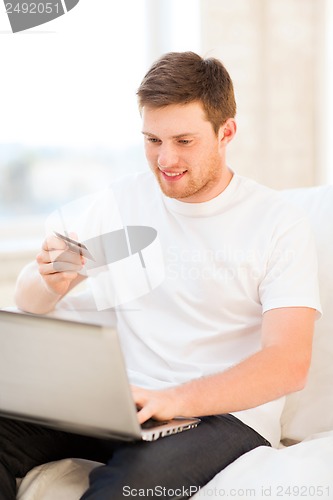 Image of man with laptop and credit card at home