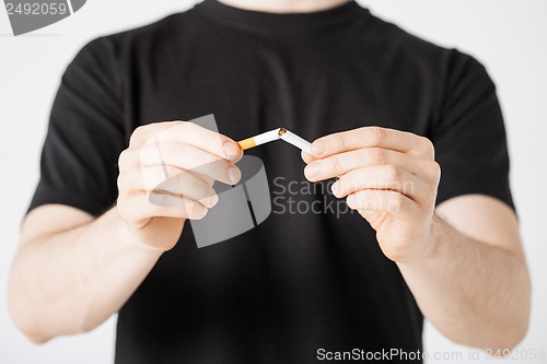 Image of man breaking the cigarette with hands