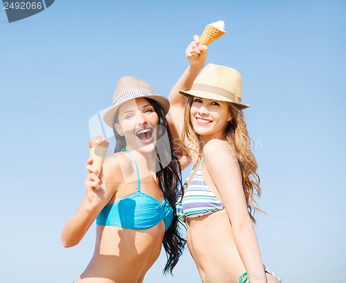 Image of girls in bikini with ice cream on the beach