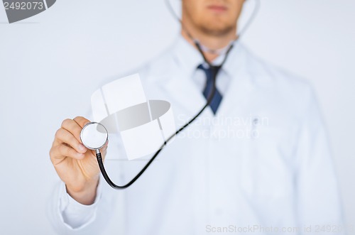 Image of doctor hand with stethoscope listening something