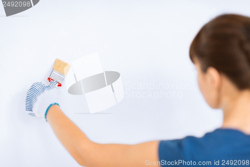 Image of woman with paintbrush colouring the wall