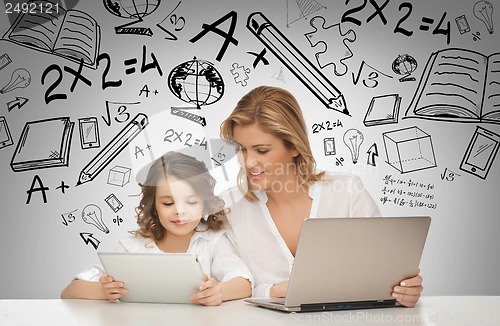 Image of girl and mother with tablet and laptop