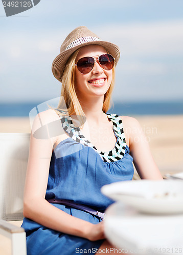 Image of girl in shades in cafe on the beach