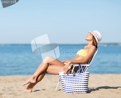 Image of girl sunbathing on the beach chair