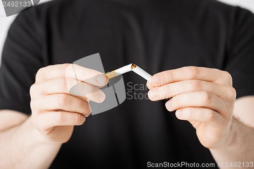 Image of man breaking the cigarette with hands