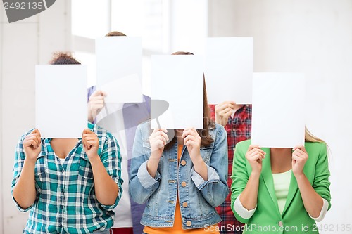 Image of students covering faces with blank papers