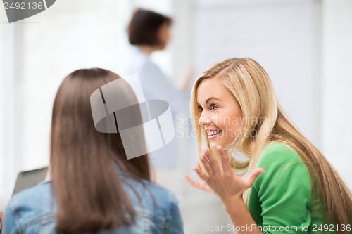 Image of student girl gossiping in lecture at school