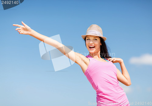 Image of girl in hat showing direction on the beach