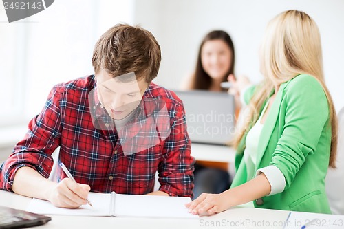 Image of students writing something at school