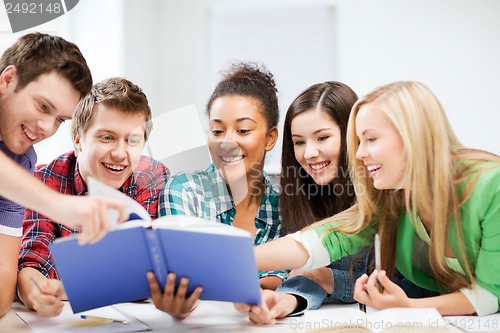 Image of students reading book at school