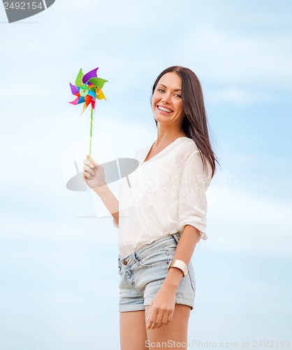 Image of girl with windmill toy on the beach