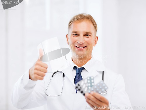 Image of male doctor with packs of pills