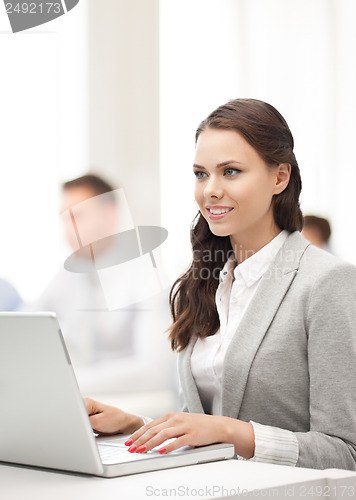 Image of businesswoman with laptop computer at work