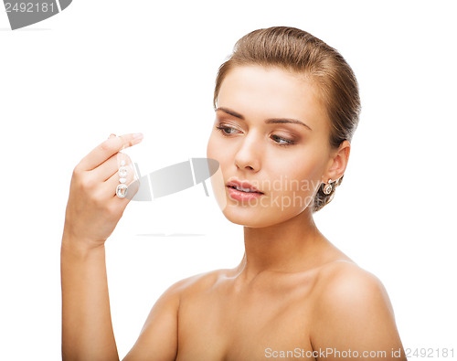 Image of woman wearing shiny diamond earrings