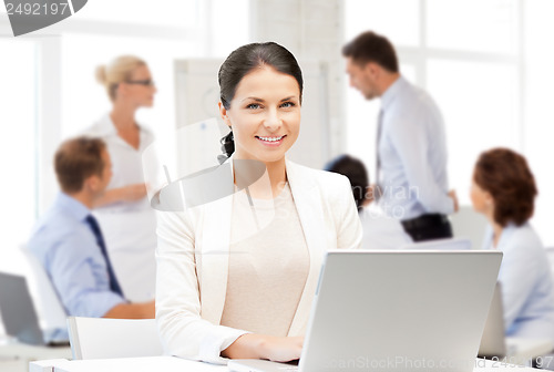 Image of businesswoman with laptop computer at work