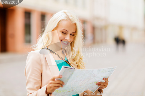Image of girl looking into tourist map in the city