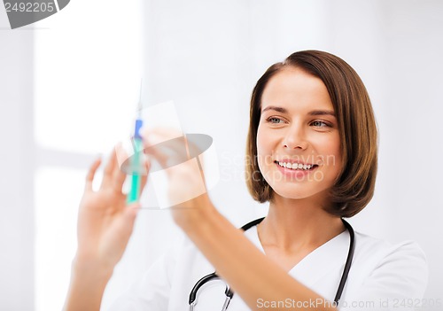 Image of female doctor holding syringe with injection