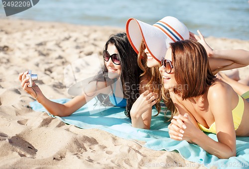 Image of girls making self portrait on the beach