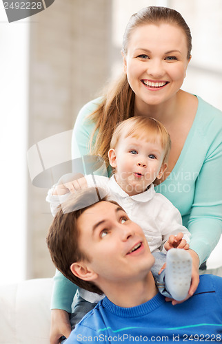 Image of happy parents playing with adorable baby