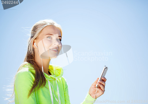 Image of woman listening to music outdoors