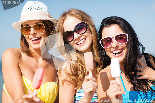 Image of girls in bikinis with ice cream on the beach