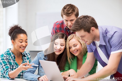 Image of international students looking at laptop at school