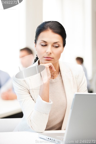 Image of businesswoman with laptop computer at work