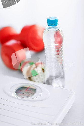Image of scales, dumbbells, bottle of water, measuring tape