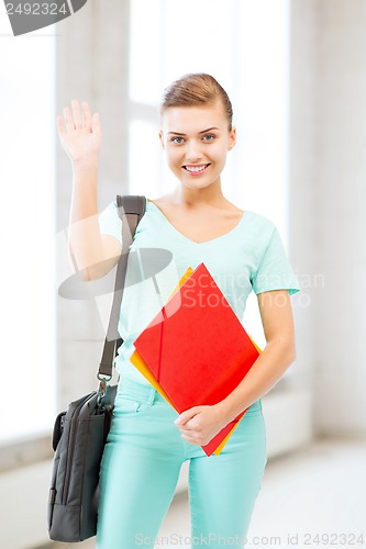 Image of student with folders and school bag in college