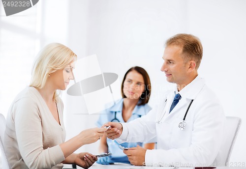 Image of doctor giving tablets to patient in hospital