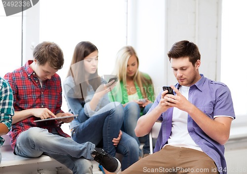 Image of students looking into devices at school