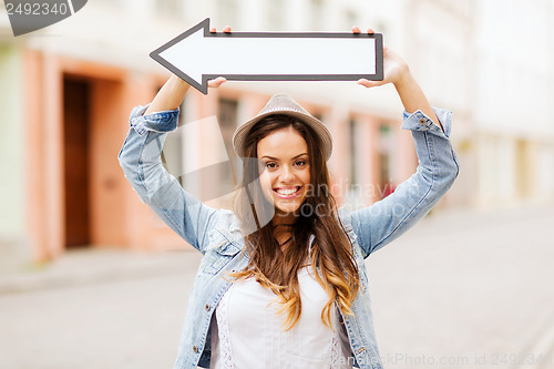 Image of girl showing direction with arrow in the city