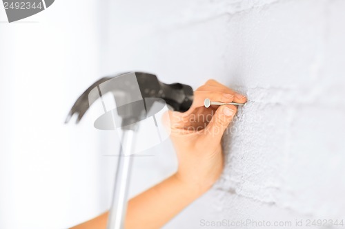 Image of architect hammering nail in wall