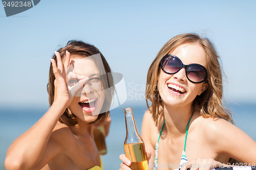 Image of girls with drinks on the beach chairs